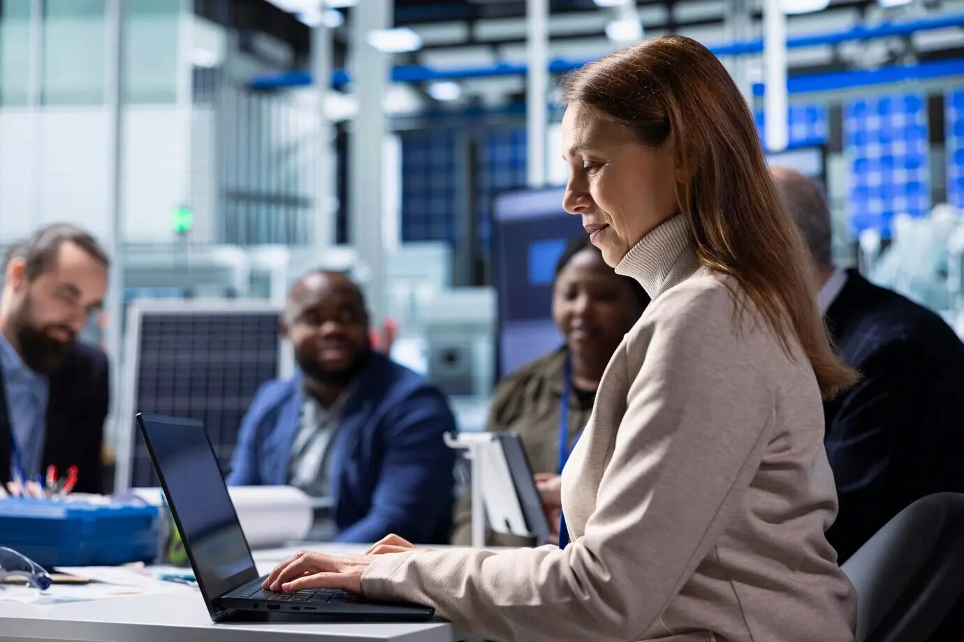 Equipo de gestión de una fábrica fotovoltaica analizando datos con un portátil